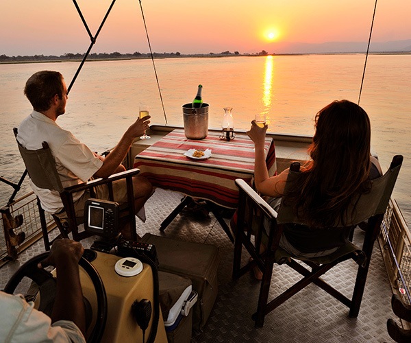 Couple enjoying sunset boat cruise at Chiawa Camp, Zambia